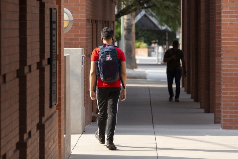 Students walk through the campus at the University of Arizona in Tucson.