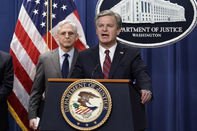 FBI Director Christopher Wray, joined at left by Attorney General Merrick Garland, speaks to reporters as they announce charges against two men suspected of being Chinese intelligence officers for attempting to obstruct a U.S. criminal investigation and prosecution of Chinese tech giant Huawei, at the Department of Justice in Washington, Monday, Oct. 23, 2022.
