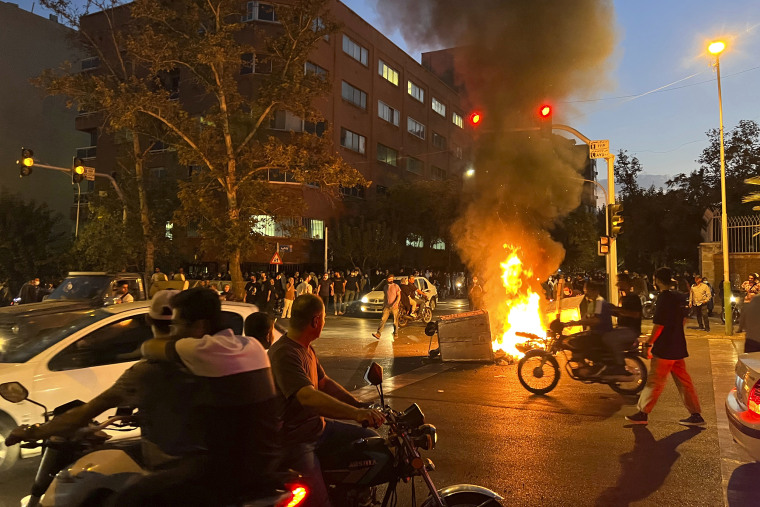 In this Monday, Sept. 19, 2022, photo taken by an individual not employed by the Associated Press and obtained by the AP outside Iran, a police motorcycle and a trash bin are burning during a protest over the death of Mahsa Amini, a 22-year-old woman who had been detained by the nation's morality police, in downtown Tehran, Iran. Spontaneous mass gatherings to persistent scattered demonstrations have unfolded elsewhere in Iran, as nationwide protests over the death of a young woman in the custody of the morality police enter their fourth week.