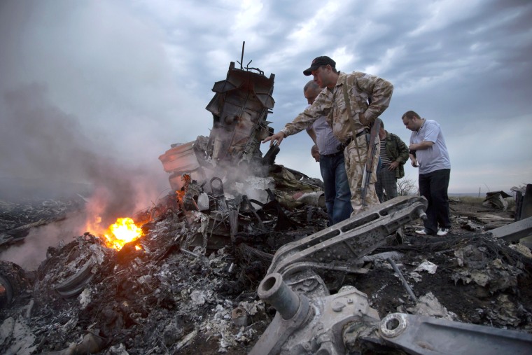 People inspect the crash site of Malaysia Airlines Flight MH17, near the village of Hrabove, Ukraine.