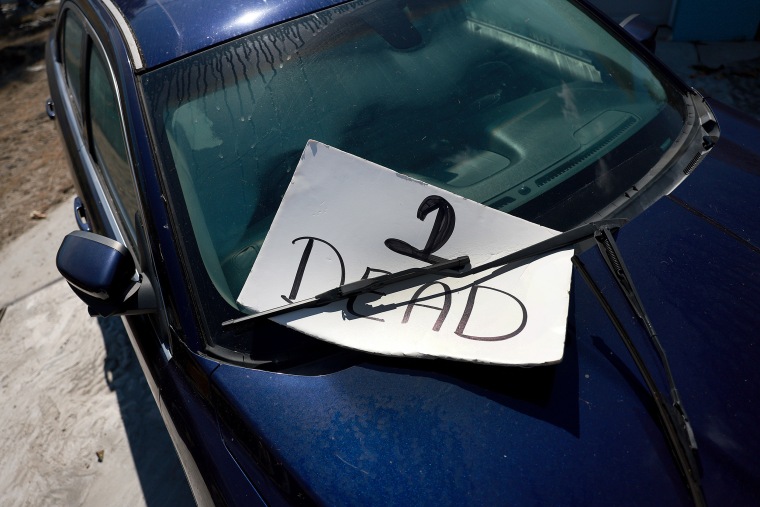 A sign posted on a vehicle reads "2 DEAD" as members of a search and rescue team work on checking homes for victims in the wake of Hurricane Ian on Oct. 3, 2022 in Fort Myers Beach, Fla.