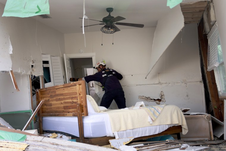 A member of a search and rescue team checks a home for victims in the wake of Hurricane Ian in Fort Myers Beach, Fla., on Oct. 3.