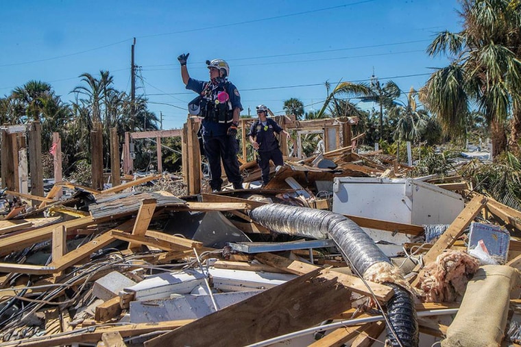 A member of a search and rescue team confirms to teammates the discovery of a body in Fort Myers Beach, Fla., on Sept. 30, two days after Hurricane Ian hit Florida's west coast.