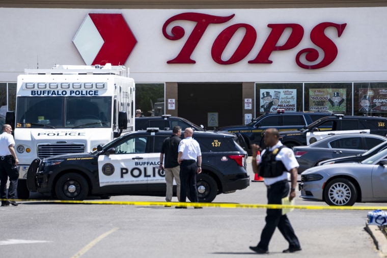 Law enforcement officials work at the scene of a mass shooting at Tops Friendly Market