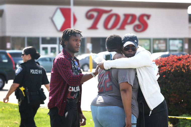 People console each other outside of Tops Friendly Market 