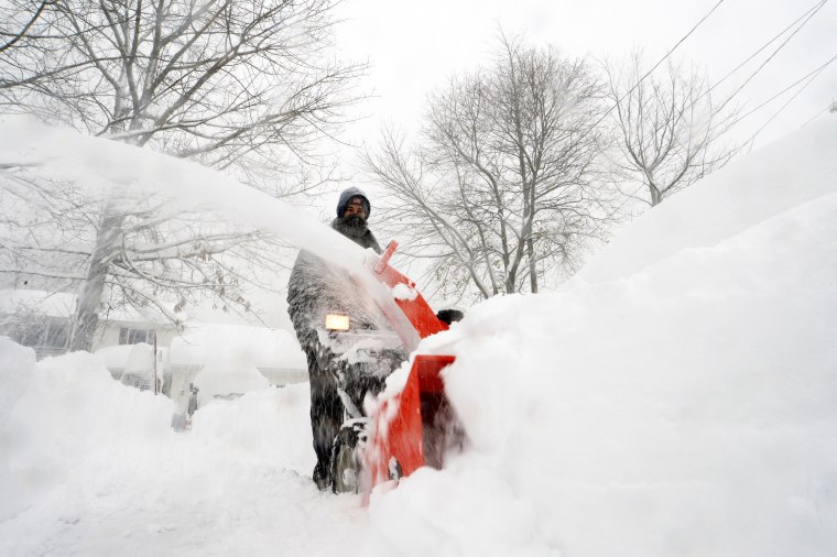 Un uomo usa uno spazzaneve per rimuovere la neve ad Amburgo, New York