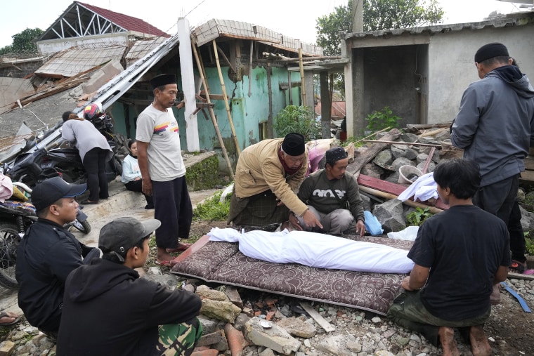 Men prepare the body of a young earthquake victim for burial in Cianjur, West Java, Indonesia Tuesday, Nov. 22, 2022. The earthquake has toppled buildings on Indonesia's densely populated main island, killing a number of people and injuring hundreds.