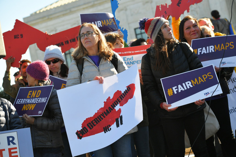 People gather during a rally at the Supreme Court in Washington, D.C. during the Supreme Court hearings on the redistricting cases
