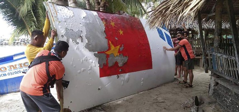 In this photo provided by the Philippine Coast Guard, Coast Guard personnel carry debris found in waters off Mamburao, the Philippines, in August that appears to be from a Chinese rocket launch the month before.