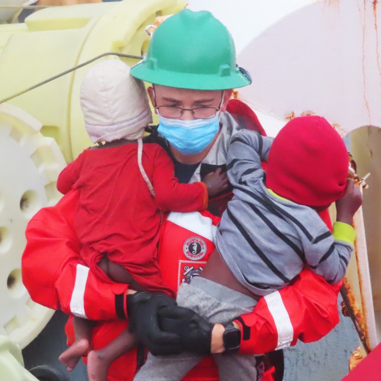 A U.S. Coast Guard official carries two children, rescued off the south coast of Florida after a vessel hit a sandbar near Whale Harbor on Monday. 