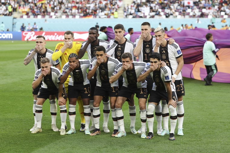 The players of Germany pose with their hands covering their mouths in the team group picture before a match between Germany and Japan at Khalifa International Stadium in Doha, Qatar, on Nov. 23, 2022.