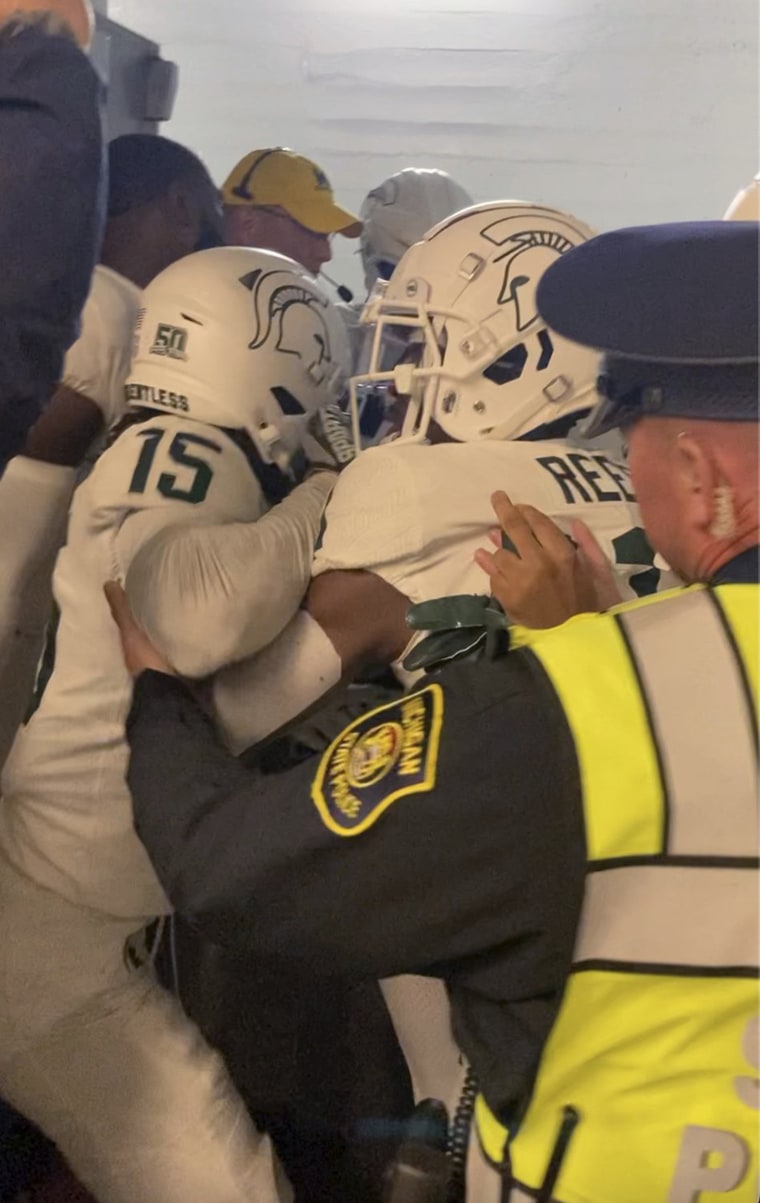 Security and police break up a fight between players from the Michigan and Michigan State football teams in the Michigan Stadium tunnel