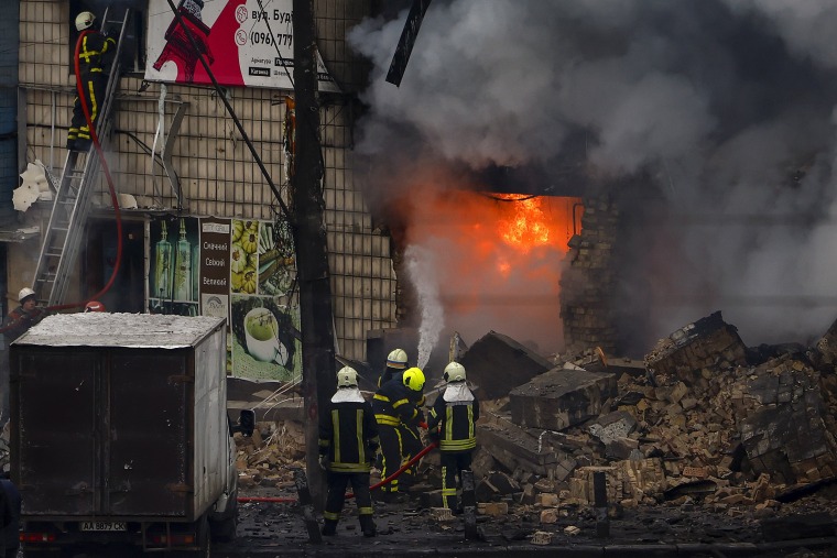Fire and rescue workers attend to a building hit by a missile in Kyiv, Ukraine