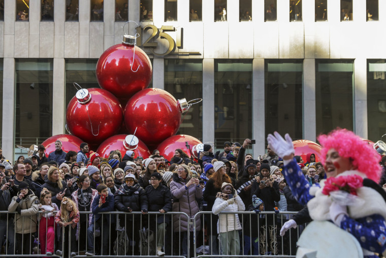 Spectators line Sixth Avenue as they watch clowns, floats and balloons go by during the Macy's Thanksgiving Day Parade.