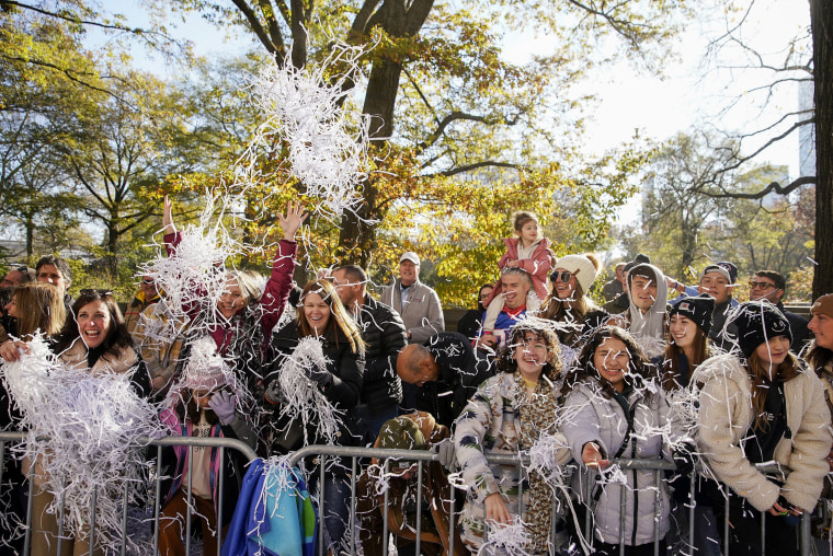 Spectators toss confetti as the parade makes its way down Central Park Avenue West during the Macy's Thanksgiving Day Parade, Nov. 24, 2022, in New York.