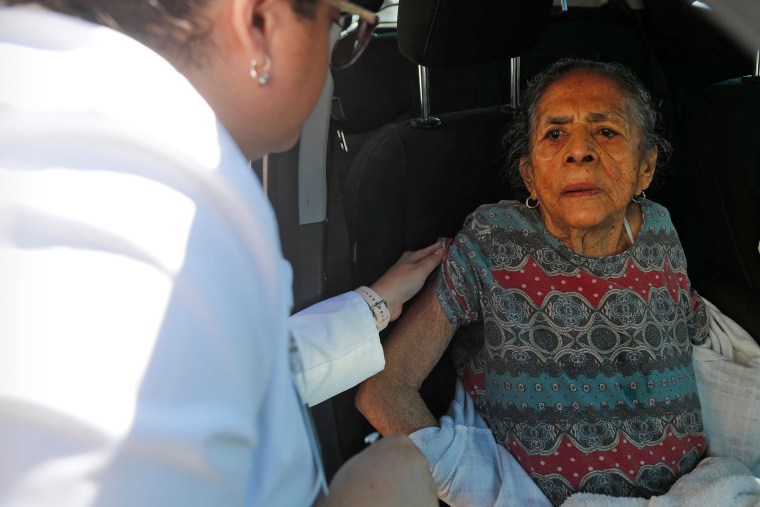 Dima Radilla, 92, receives a flu vaccination during a drive-through clinic in Garden City, Ga., on Nov. 22, 2022.