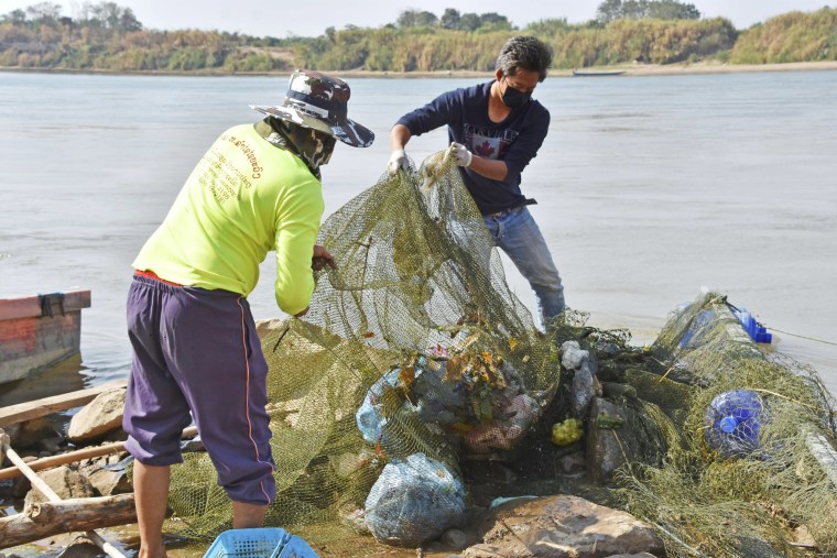 Officials collect plastic waste from the Mekong River in Vientiane, Laos, in 2020. 