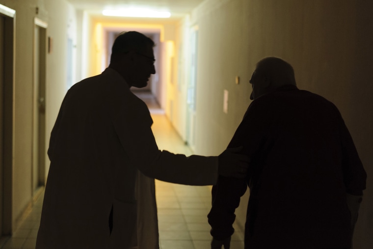 Ukrainian doctor Oleh Duda, left, speaks with a patient at the hospital in Lviv on Saturday. 