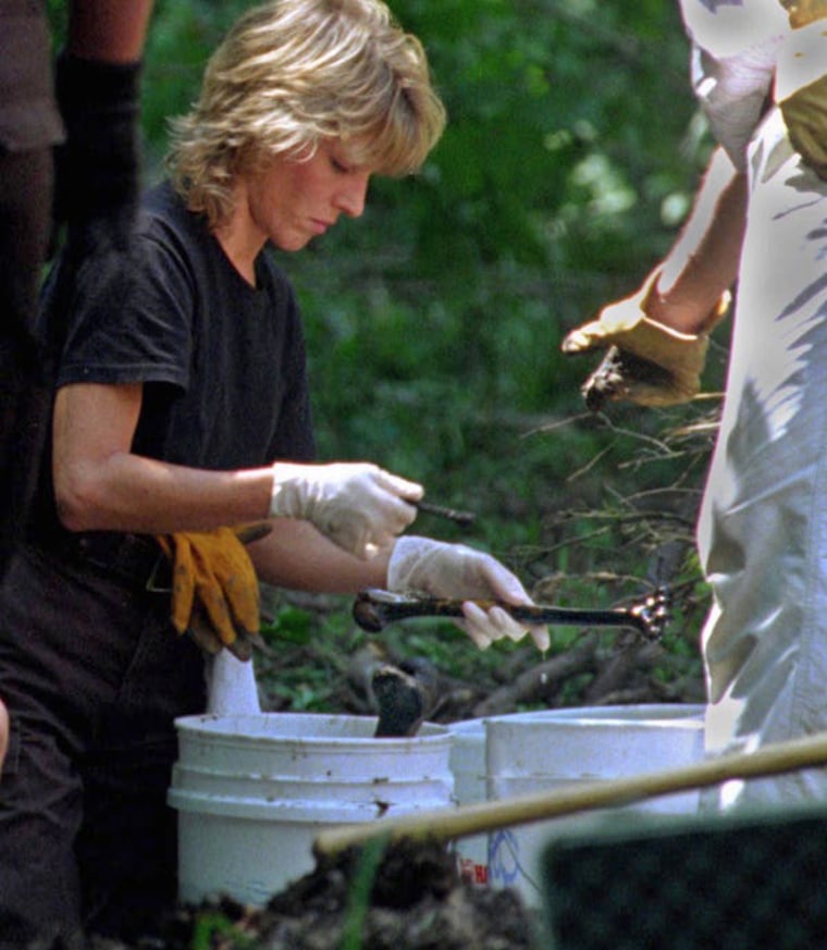 A technician with the Hamilton County Sheriff's Department examines human bones in a wooded area at Fox Hallow Farm in 1996.