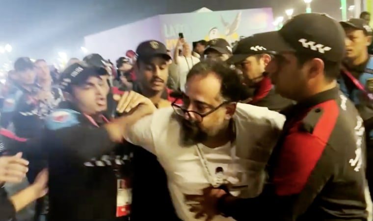 World Cup stadium security staffers pin down an Iranian wearing a protest T-shirt in Doha, Qatar, on Tuesday. 