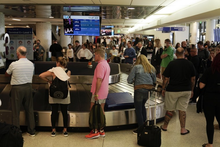 Viajeros esperan para recoger su equipaje en el Aeropuerto Internacional de Los Ángeles, California, el viernes 1 de julio de 2022.