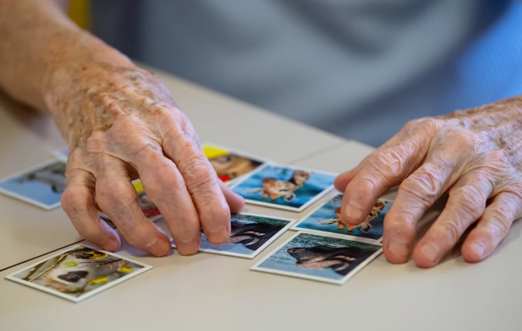 Una residente de un hogar de ancianos juega el juego "Memoria" para ayudar a ejercitar sus capacidades en una sala de enfermería.
