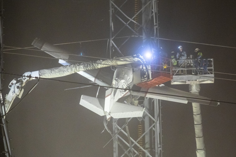 Los trabajadores de emergencia estabilizan un avión que se estrelló contra una torre de líneas eléctricas de alta tensión antes de poder sacar a las personas que estaban en el avión, en Montgomery Village, Maryland, 27 de noviembre de 2022.