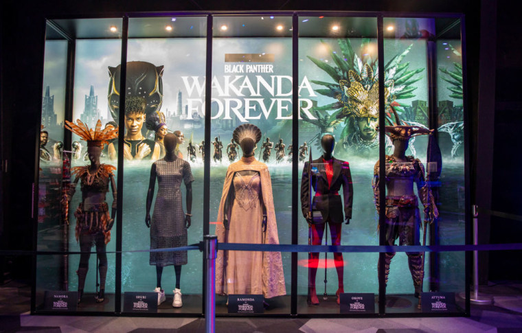 Una exhibición de vestuarios de "Pantera Negra: Wakanda por siempre" en Disneyland California. De izquierda a derecha muestra el vestuario con inspiración maya del personaje Namora, los vestuarios de personajes de Wakanda Shuri, Ramonda y Okoye, y el atuendo de inspiración mesoamericana para Attuma