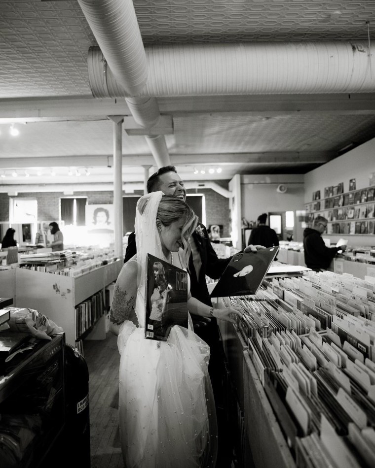 A bride and groom at a record shop with Taylor Swift's album "Red"