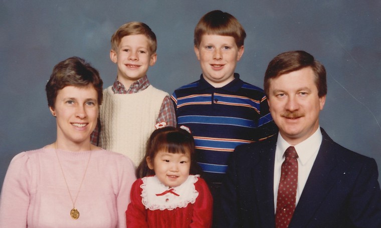 The author (bottom middle, in red) as a young girl with her family.