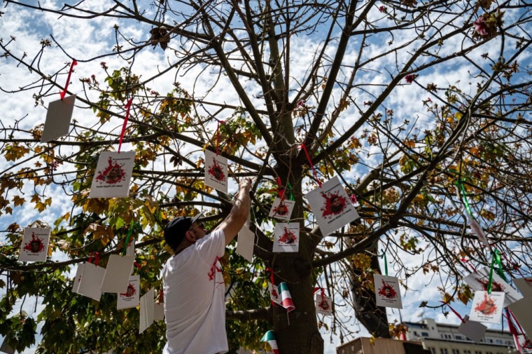 Fotos de mujeres iraníes asesinadas, colgadas en un árbol frente al Palacio de la Moneda en Santiago de Chile, el 25 de noviembre de 2022.