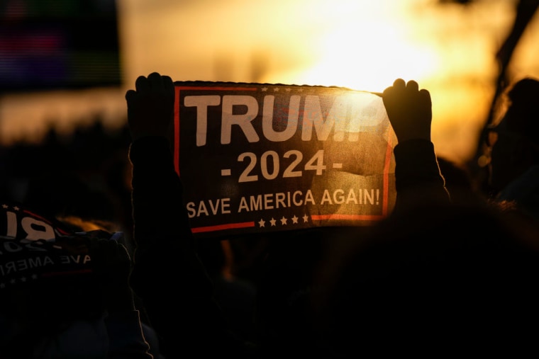 Un seguidor del expresidente Donald Trump muestra un cartel con un mensaje a favor de su candidatura presidencial para 2024, durante un acto de campaña en Vandalia, Ohio, el 7 de noviembre de 2022.