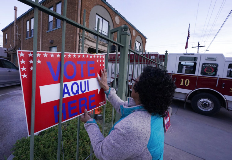 Una funcionaria electoral coloca un letrero en El Paso, Texas, este 8 de noviembre.