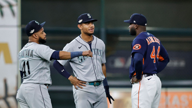 Tres jugadores de béisbol afrolatinos, Carlos Santana, Julio Rodríguez y Yordan Álvarez hablan durante un partido entre los Mariners de Seattle y los Astros de Houston