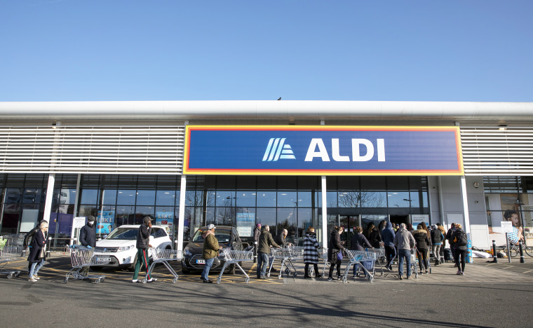 Shoppers queue outside an Aldi supermarket