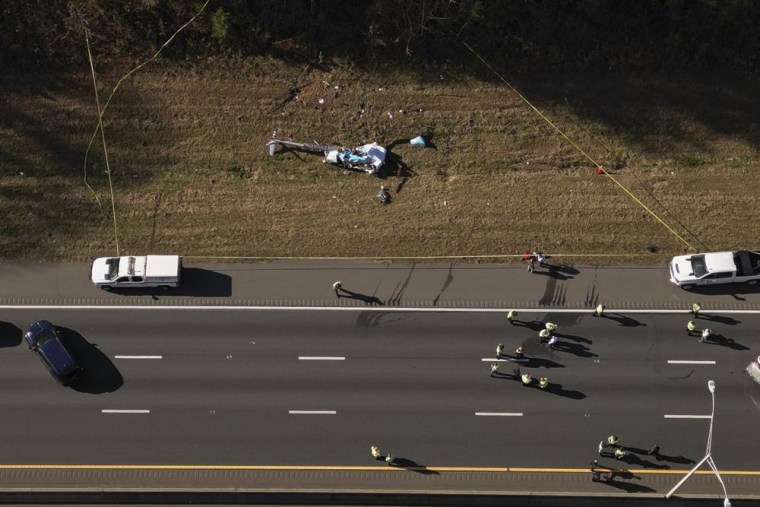 In this image take with a drone, emergency personnel work at the scene of a helicopter crash on the side of Interstate 77 South in Charlotte, N.C., Tuesday, Nov. 22, 2022. Authorities said two people died.
