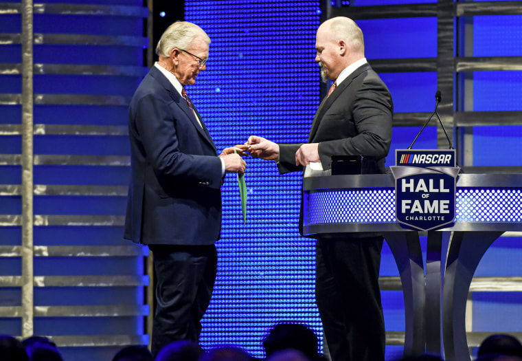 Coy Gibbs, right, presents the Hall of Fame ring to his father, NASCAR Hall of Fame inductee Joe Gibbs.