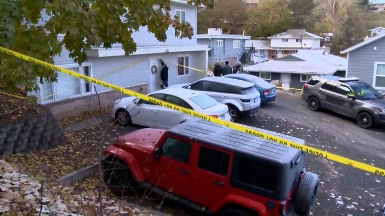 Cars outside a house in a residential neighborhood with yellow caution tape.