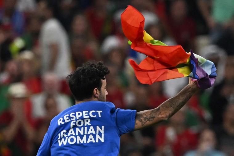 Mario Ferri, de 35 años, entra a la cancha con una camiseta que dice "Respeto a la mujer iraní" y  ondeando una bandera con los colores del arco iris  durante el partido entre Portugal y Uruguay el 28 de noviembre de 2022.