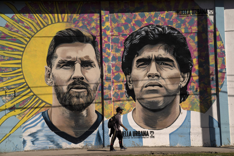 Un peatón pasa frente a un mural que representa a las leyendas del fútbol Lionel Messi y Diego Maradona, en Buenos Aires, Argentina.
