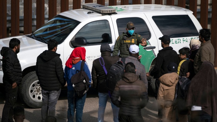 Un agente de la patrulla fronteriza habla con un grupo de migrantes antes de procesarlos después de cruzar la frontera entre México y Estados Unidos, tomada en Tijuana, estado de Baja California, México, el 11 de noviembre de 2022.