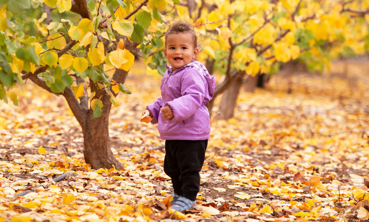 A child among the falling leaves.