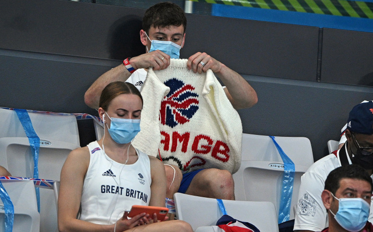 Thomas Daley with his knitting as he watches divers in the preliminary round of the men's 3m springboard diving event.