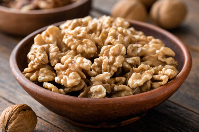 Walnuts in a brown bowl.