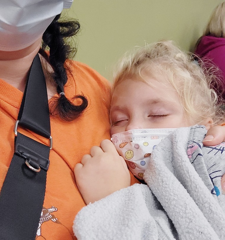 Shelby Templin holds her 4-year-old daughter upright so she can breathe while waiting to be treated.