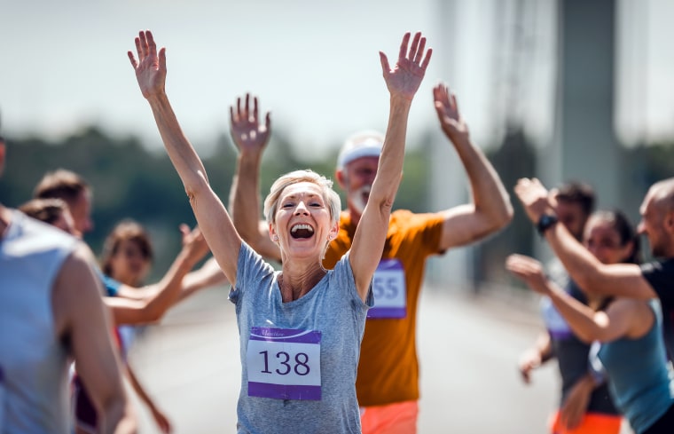 Older woman successfully finishing a marathon.