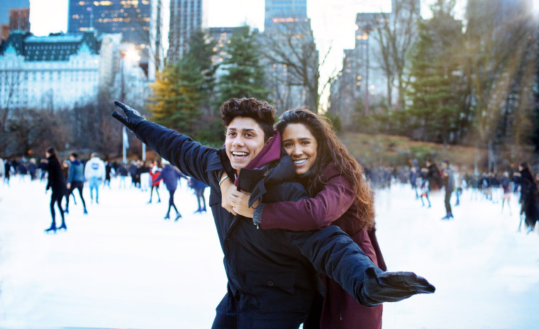 Portrait of a happy young couple smiling and hugging while ice skating.