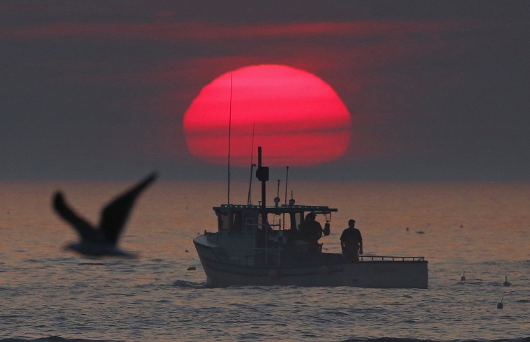 A lobster boat heads out to sea at sunrise, off Kennebunkport, Maine, in 2015.