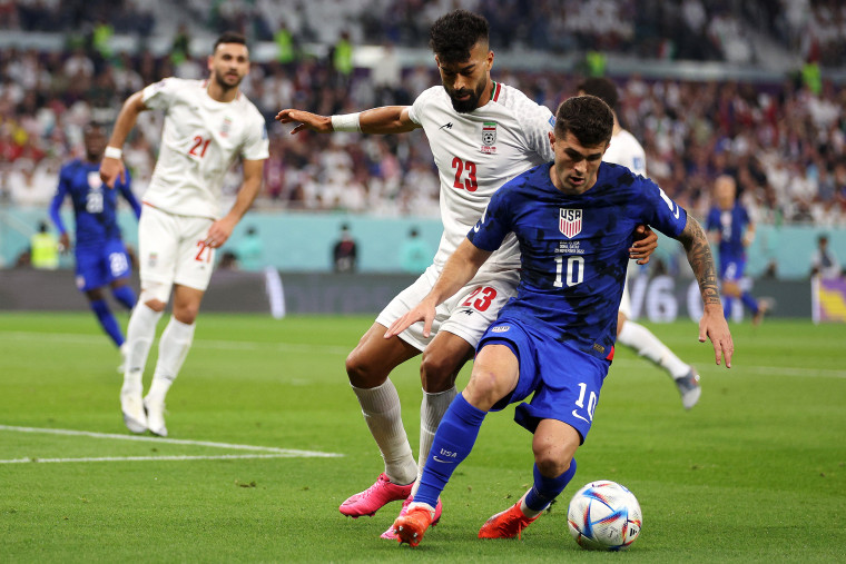 Christian Pulisic of USA battles for the ball with Ramin Rezaeian of Iran during the FIFA World Cup Qatar 2022 Group B match between IR Iran and USA at Al Thumama Stadium on November 29, 2022 in Doha, Qatar.