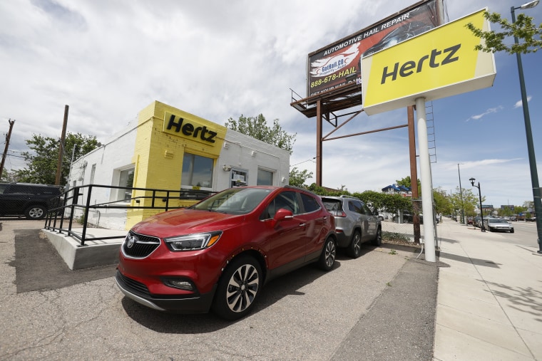 Rental vehicles parked outside a Hertz car rental office in Denver.